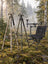 BOG DeathGrip-tripod i Mossy Oak Bottomland, DeathGrip Infinite-tripod i aluminium och ChairPod-jaktstol i en nordisk granskog en dimmig höstmorgon